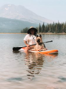 woman paddle boarding with a dog