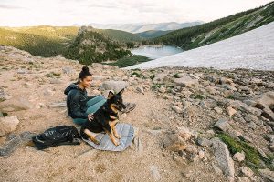 woman and dog camping using one of the best dog camping beds