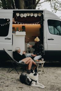couple camping in an RV with dogs