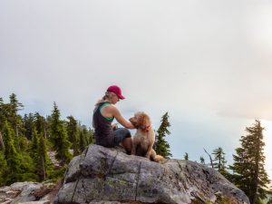 woman and dog hiking on a mountain; If you're wondering, can dogs get altitude sickness? This guide will provide you with answers.